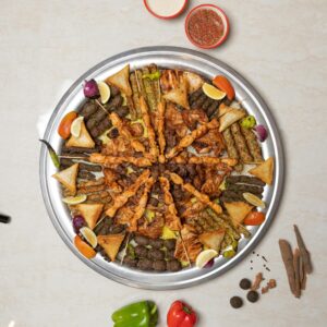 Delicious Middle Eastern kebab platter with various meats and fresh vegetables, top view.