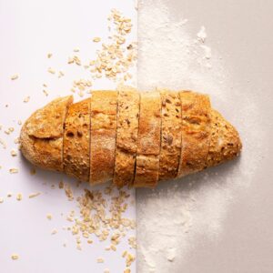 Freshly sliced whole grain bread with oats and flour provides a rustic and nutritious appeal.