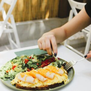 A vibrant breakfast plate featuring an omelette and fresh leafy salad on a sunlit table.