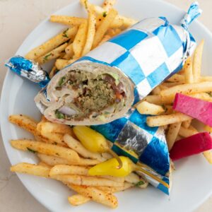 Delicious falafel shawarma wrap with crispy fries served on a plate in Santa Monica.