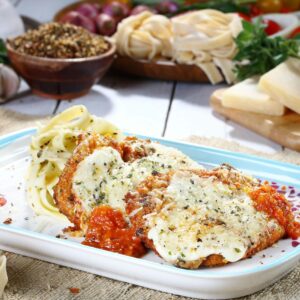 Tasty chicken parmesan with pasta and fresh ingredients on a rustic table.