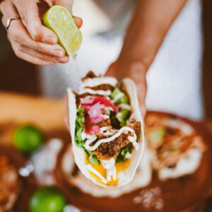 A close-up of a taco with lime juice squeezed over, showcasing vibrant and fresh ingredients.